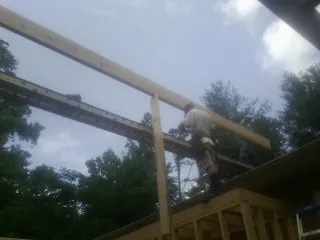 Carpenter setting a ridge beam over a new addition frame — Ice Dam Removal by Roofing Brothers in Torrance