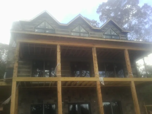 Dormers and porch framing on a large log home under construction — Roof Coating work by our crew in Torrance
